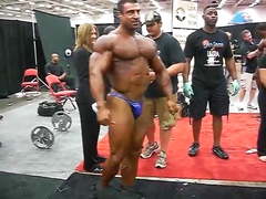 Str8 Greek bodybuilder flexing in backstage